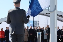 Der finnische Präsident Sauli Niinisto, Mitte, spricht, während Militärangehörige sich darauf vorbereiten, Finnlands Flagge während einer Zeremonie für die NATO-Mitgliedschaft des Landes im Hauptquartier des Bündnisses in Brüssel am 4. April 2023 zu hissen.