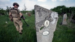 A Ukrainian sapper demines the cemetery on the site of heavy battles with Russian troops in the village of Krasnopillya, Donetsk region, Ukraine, May 2, 2024. (Iryna Rybakova via AP)