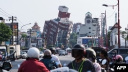 Warga lokal berkendara melewati sejumlah bangunan yang rusak akibat gempa di Hualien, Taiwan, pada 4 April 2024. (Foto: AFP/Sam Yeh)
