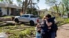 FILE - Neighbors embrace Penny Thomsen outside of her home after tornadoes hit the evening before, Des Moines suburb of Pleasant Hill, Iowa, Apr. 27, 2024. In Oklahoma, 2 people were killed in tornadoes. (Zach Boyden-Holmes/The Register/USA Today Network via Reuters)
