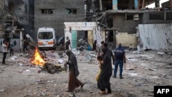 Palestinos observan los escombros de una casa familiar que fue alcanzada durante la noche en un bombardeo israelí en el barrio Tal al-Sultan de Rafah, en el sur de Gaza, el 20 de mayo de 2024.