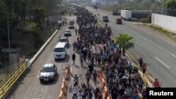 Migrants take part in a mass protest procession toward Mexico City in memory of the 40 migrants who died during a fire at a migrant detention center as they walk along the road en route to Viva Mexico, Chiapas state, Mexico April 23, 2023.