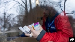 Una voluntaria médico de FRIDA Ucrania busca medicamentos para un paciente mientras brinda atención médica especializada a civiles en la aldea de Khrestysche, región de Donetsk, Ucrania, el domingo 19 de marzo de 2023.