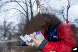 Relawan medis FRIDA Ukraina mencari obat untuk seorang pasien yang merupakan warga sipil di Desa Khrestysche, wilayah Donetsk, Ukraina, Minggu, 19 Maret 2023. (Foto: AP)