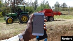 Aplikasi ponsel menunjukkan pergerakan traktor John Deere 5503, dipasang dengan teknologi Hello Tractor yang menghubungkan petani dengan pemilik kendaraan, di desa Umande di Nanyuki, Kenya, 4 Februari 2020. ( REUTERS/Njeri Mwangi)