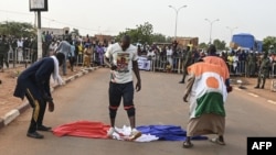 Des manifestants profanent un drapeau français lors d'un rassemblement à Niamey, le 1er septembre 2023, exigeant le départ des troupes françaises du Niger.