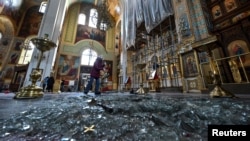 Žena uklanja ruševine unutar katedrale oštećene ruskim raketnim udarom, usred ruskog napada na Ukrajinu, u Zaporožju, Ukrajina, 18. oktobra 2023.