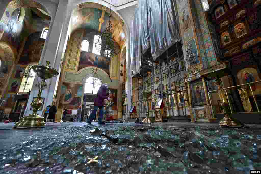 A woman removes debris inside a cathedral damaged by a Russian missile strike in Zaporizhzhia, Ukraine.