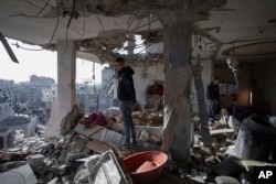 Palestinians look at a damaged residential building after an Israeli strike in Rafah, southern Gaza Strip, Jan. 10, 2024.