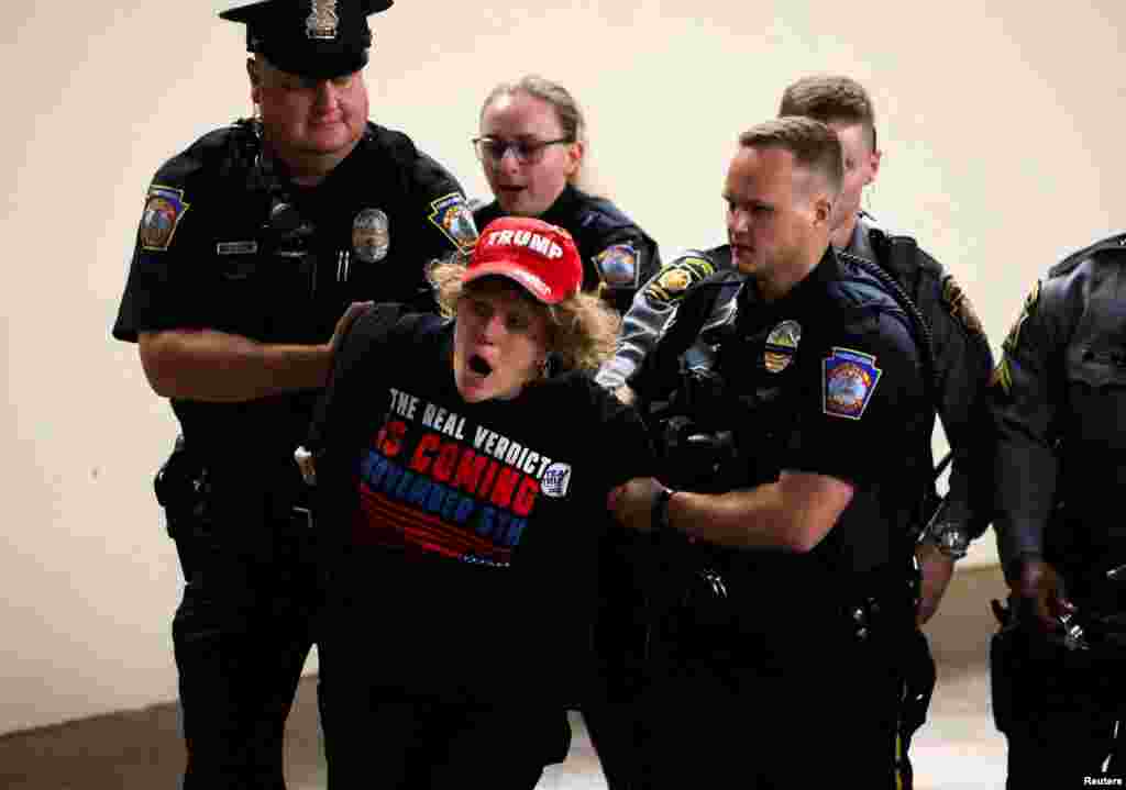 Police detain a woman during the campaign rally of Republican presidential nominee and former U.S. President Donald Trump, in Harrisburg, Pennsylvania, July 31, 2024. 