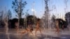 FILE - Children cool off as they play on a fountain at Stavros Niarchos Foundation Cultural Center, in Athens, Greece, July 18, 2024. (AP Photo/Petros Giannakouris)