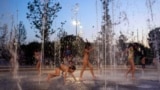 FILE - Children cool off as they play on a fountain at Stavros Niarchos Foundation Cultural Center, in Athens, Greece, July 18, 2024. (AP Photo/Petros Giannakouris)