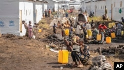 People displaced by the ongoing fighting between Congolese forces and FILE - M23 rebels gather in a camp on the outskirts of Goma, Democratic Republic of Congo, March 13, 2024, 