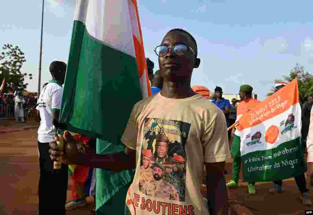 A boy holds a national flag as supporters of Niger&#39;s National Council of Safeguard of the Homeland (CNSP) gather to protest ouside the Niger and French airbase to demand the departure of the French army from Niger, in Niamey on September 16, 2023.&nbsp;