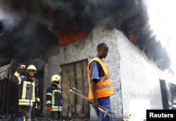 Firefighters arrive to extinguish a fire at the Baraka market after an explosion in the shopping area in Mogadishu, March 10, 2024.
