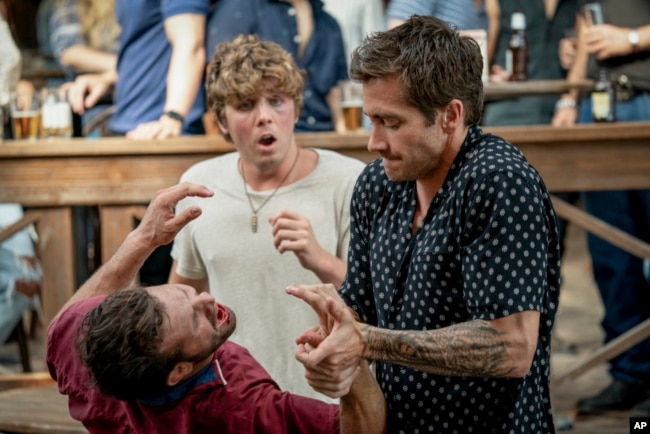 Aktor Lukas Gage (belakang) dan Jake Gyllenhaal (kanan) dalam sebuah adegan di film "Road House" (Laura Radford/Prime Video via AP)