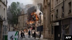 Asap mengepul dari reruntuhan gedung di Place Alphonse-Laveran di Paris yang terbakar pada 21 Juni 2023. (Foto: AFP/Abdulmonam Eassa)