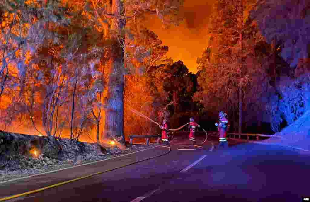 In this handout image released by Military Emergency Unit, military firefighters battle a forest fire on Aug. 17, 2023 raging in the northeastern part of Spain's Canary island of Tenerife.