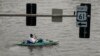 Seorang pria mengayuh kayaknya untuk menelusuri jalanan yang tergenang banjir di pusat kota Davenport, Iowa. (AP)&nbsp;