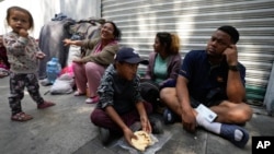 A migrant family from Venezuela eats breakfast alongside the railroad tracks in Mexico City, March 26, 2024.