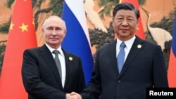 ប្រធានាធិបតីរុស្ស៊ីលោក Vladimir Putin និងប្រធានាធិបតីចិនលោក Xi Jinping ចាប់ដៃគ្នា ក្នុងជំនួបមួយនៃវេទិកាគម្រោងផ្លូវក្រវ៉ាត់ពាណិជ្ជកម្ម នៅទីក្រុងប៉េកាំង ប្រទេសចិន ថ្ងៃទី ១៨ ខែតុលា ឆ្នាំ ២០២៣។ (Sputnik/Sergei Guneev/Pool via REUTERS)