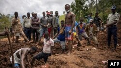 Residents and volunteers dig in the mud in search for bodies at the scene of a landslide in the Kencho Shacha Gozdi district of southern Ethiopia, July 25, 2024.