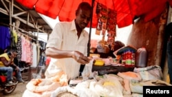 FILE - A vendor is seen in the Mvog Ada market in Yaounde, Cameroon, Jan. 29, 2022. Officials said plastic bag pollution in the country has doubled in the past four years to 600,000 tons.