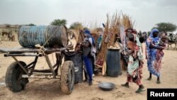 Una mujer sudanesa que huyó de la violencia en su país intenta sacar agua de un barril cerca de la frontera entre Sudán y Chad, el 26 de abril de 2023. La crisis ha enviado a un número creciente de refugiados a cruzar las fronteras de Sudán.