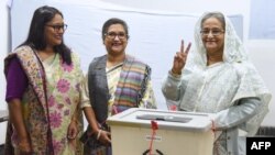 FILE - Bangladeshi Prime Minister Sheikh Hasina flashes the victory symbol after casting her vote, as her daughter Saima Wazed and her sister Sheikh Rehana look on in Dhaka, Dec. 30, 2018. Wazed's nomination for a senior regional WHO position has triggered controversy.