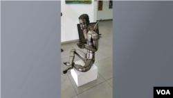 Homem afiando o seu instrumento de caça. Escultura de metal criada por artista plástico moçambicano, Djerry.