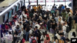 Para penumpang antre untuk check in di bandara internasional Don Mueang di Bangkok, Thailand, akibat sistem Windows down yang mengacaukan sitem komputer maskapai penerbangan, Jumat (19/7). 