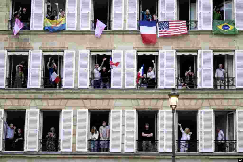 Espectadores con diversas banderas internacionales animando desde sus balcones son fotografiados desde el barco de la delegación de Brasil.