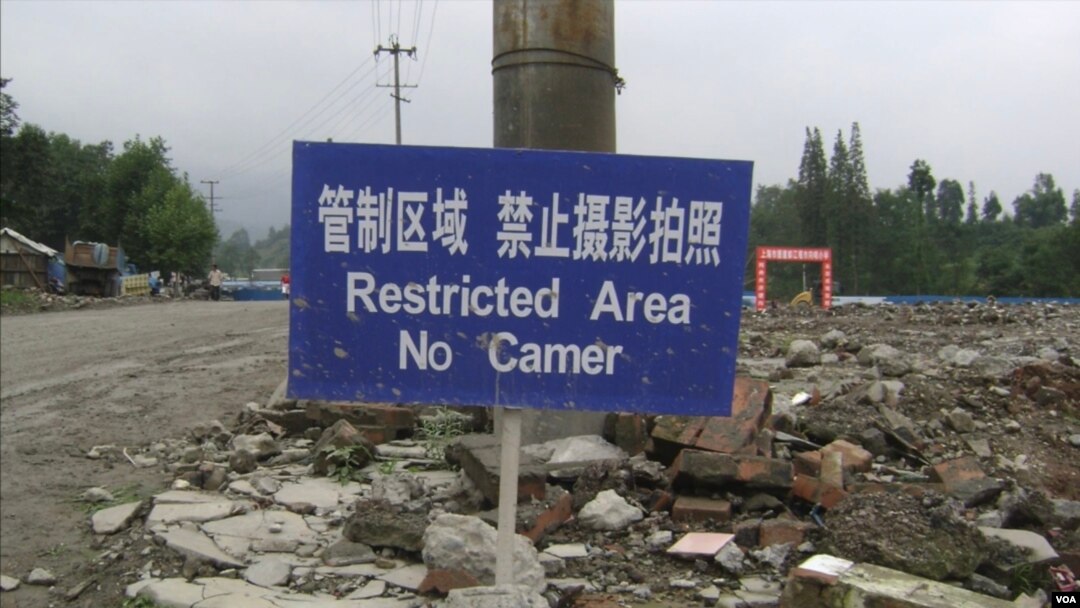2008年6月,汶川地震废墟现场,挂着“管制区域,禁止摄影拍照的牌子”