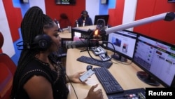 FILE - A radio presenter speaks about the second case of the coronavirus afftected in Nigeria at the studio of HOT FM station in Lagos, Nigeria March 9, 2020.