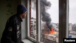 Un residente local observa los edificios dañados por un ataque militar ruso, en medio del ataque de Rusia a Ucrania, en la ciudad de Chasiv Yar, en la región de Donetsk, Ucrania, el 27 de febrero de 2023. REUTERS/Yevhen Titov