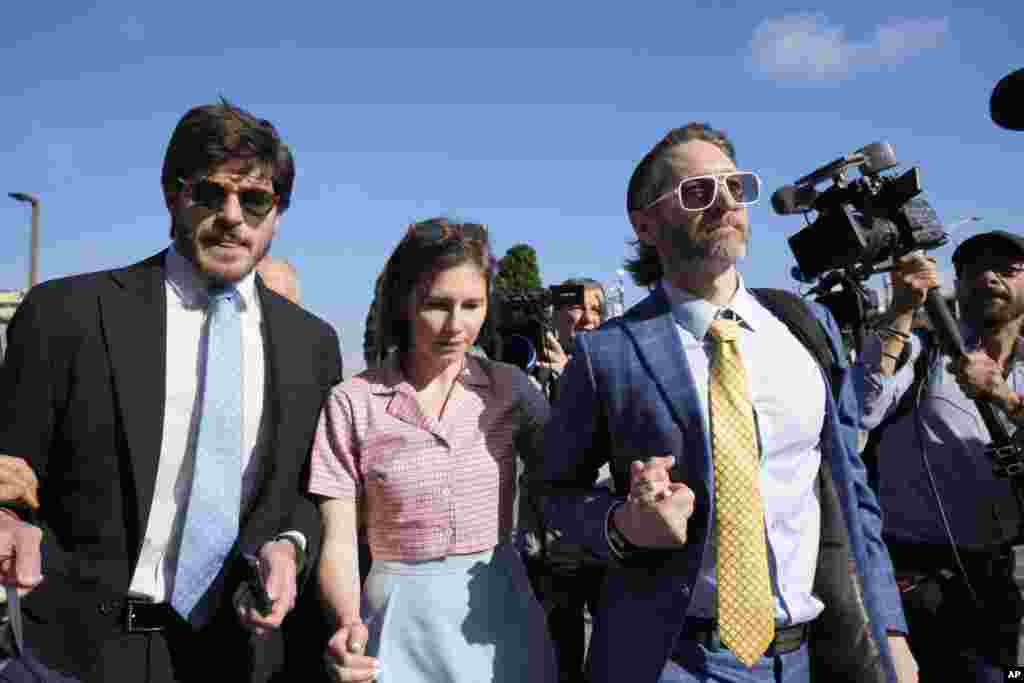 Amanda Knox arrives flanked by her husband Christopher Robinson, right, and her layer Luca Luparia Donati at the Florence courtroom in Florence.&nbsp;Amanda Knox returns to an Italian courtroom for the first time in more than 12&frac12; years to clear herself &quot;once and for all&quot; of a slander charge that stuck even after she was exonerated in the brutal 2007 murder of her British roommate in the idyllic hilltop town of Perugia.