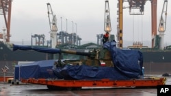 FILE - A worker uncovers South Korean Thunder K9 howitzer in the Polish Navy port of Gdynia, Poland, Dec. 6, 2022. A leaked US memo allegedly describes discussions within South Korea’s presidential office about whether to provide weapons to Ukraine.