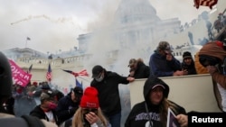 Partidarios del entonces presidente de Estados Unidos, Donald Trump, son vistos durante un enfrentamiento con agentes de policía frente al edificio del Capitolio de EEUU en Washington, el 6 de enero de 2021.