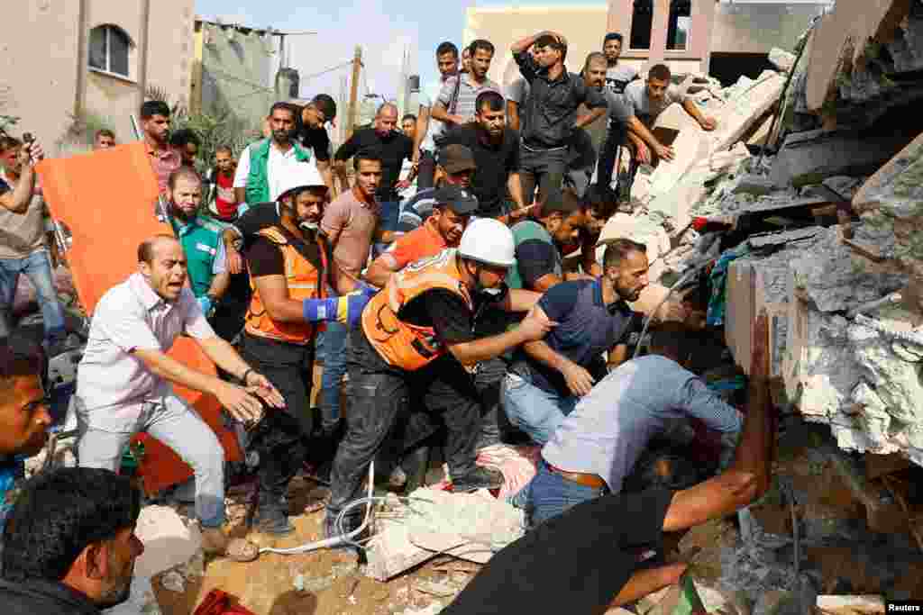 Palestinians search for people under the rubble of a house destroyed in Israeli strikes in Khan Younis, in the southern Gaza Strip.&nbsp;Israel battered Gaza after suffering its bloodiest attack in decades, when Hamas fighters rampaged through Israeli towns killing 600 and abducting dozens more.