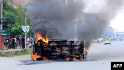 ভারতের মণিপুর রাজ্যের রাজধানী ইম্ফলে মেইতাই সম্প্রদায়ের সদস্যদের দেয়া আগুনে একটি গাড়ি থেকে ধোঁয়া বের হচ্ছে; ৪ মে ২০২৩।