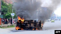 Smoke billows from a vehicle allegedly burned by the Meitei community tribals protesting to demand inclusion under the Scheduled Tribe category, in Imphal, the capital of India's Manipur state, on May 4, 2023.