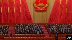 FILE - Delegates applaud as Chinese President Xi Jinping, left, arrives at the closing ceremony for China's National People's Congress at the Great Hall of the People in Beijing, March 13, 2023. Xi has urged his nation to pursue a role as a global tech power.