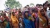 FILE - Onlookers stand at the site where two teenage girls, who were raped, were hanged from a tree at Budaun district in the northern Indian state of Uttar Pradesh, May 31, 2014. 
