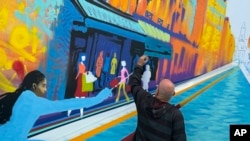 Street artist Marko93 works on a piece during a live artistic performance at City Hall, during the 2024 Summer Olympics, July 31, 2024, in Paris.