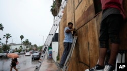 Employees cover store windows before the arrival of Hurricane Norma, in Cabo San Lucas, Mexico, Oct. 20, 2023. Norma is heading for the southern tip of Mexico's Baja California Peninsula, while Tammy churns in the Atlantic.