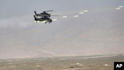 FILE - In this handout photo released by Russian Defense Ministry Press Service, Chinese military helicopter gunships fire rockets during joint war games held by Russia and China in northwestern China, Aug. 13, 2021. 