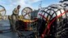 在美国海军发布的这张图片中，美国海军人员2023年2月10日准备将在南卡罗来纳州默特尔海滩（Myrtle Beach）海岸附近寻回的材料运往联邦调查局，这些材料是从中国高空气球被击落后回收的。