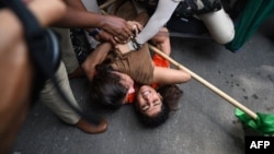 Indian wrestlers Sangeeta Phogat and Vinesh Phogat struggle as they are detained by the police during a protest against Brij Bhushan Singh, the wrestling federation chief, in New Delhi on May 28, 2023.
