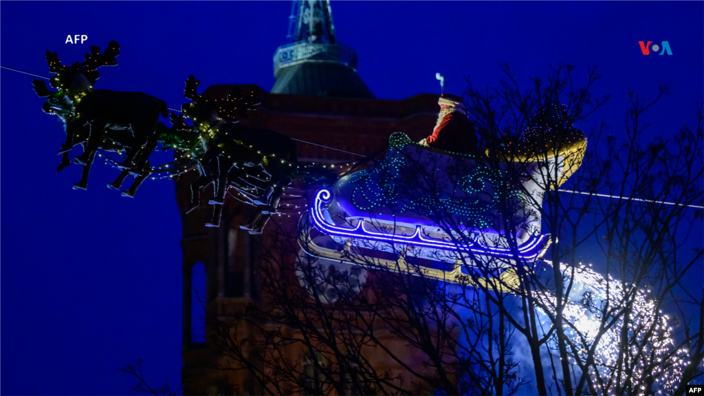 Desde Alemania: Un artista vestido como Papá Noel monta su trineo con renos sobre un tradicional mercado navideño y la torre del ayuntamiento de Berlín al fondo, en Berlín, Alemania.