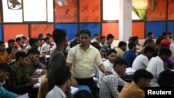 Maroof Ahmed, a maths instructor and Super Climax Academy founder, interacts with students inside a class at Super Climax Academy, a popular coaching institute training students to secure government jobs, in Prayagraj, India, June 21, 2024. 